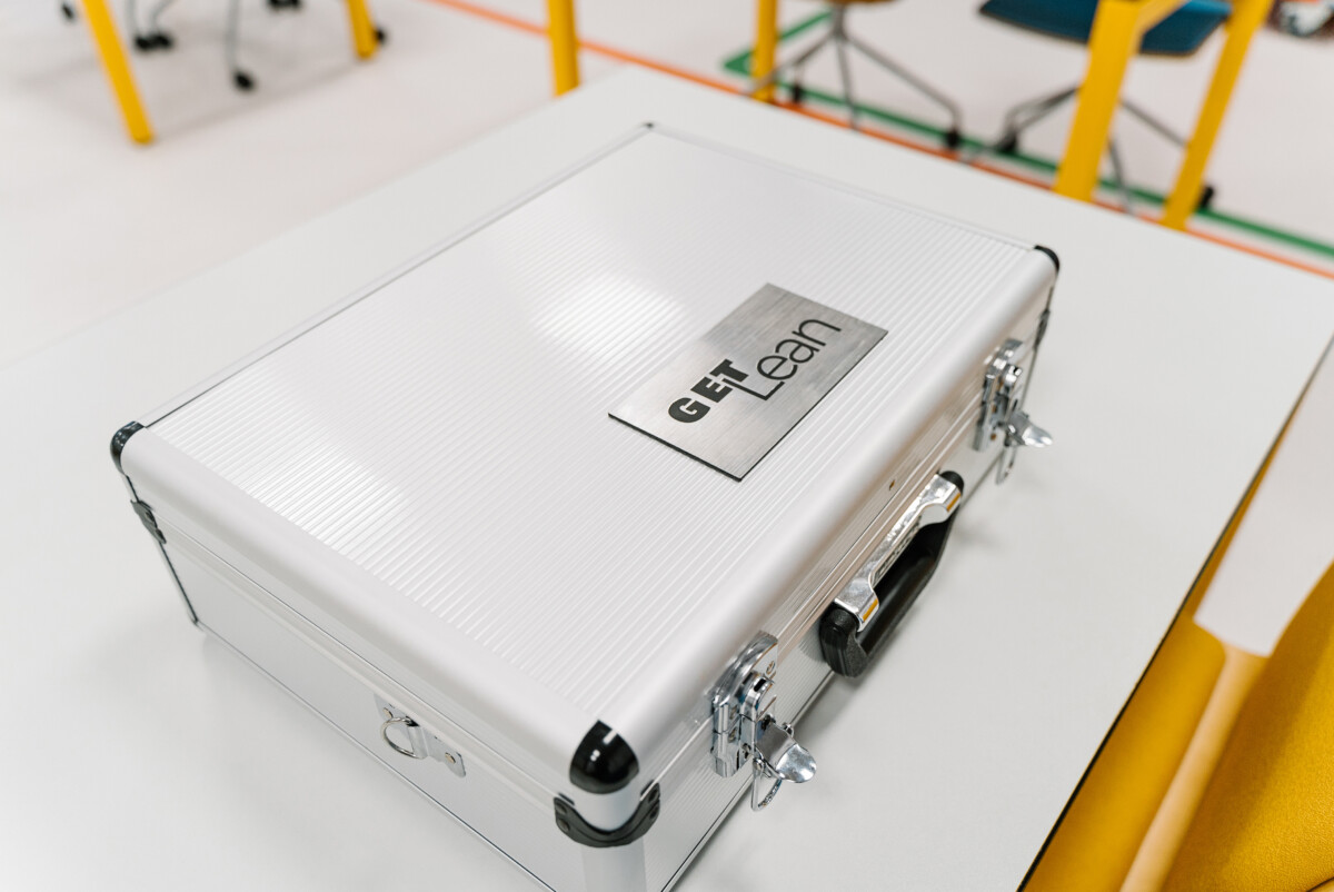 Metal case with the GET Lean logo used for delivering lean manufacturing games in hands-on training sessions.
