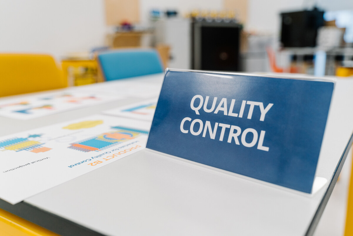 Quality Control sign on a table with training sheets used in the game Lean.